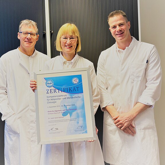 Bild mit Urkunde. Dr. Karin Hüttner, Ärztliche Leiterin des Adipositaszentrums, Dr. Oliver Ponsel, Direktor der Klinik für Allgemein- und Viszeralchirurgie und Oberarzt Dr. (Univ. Niš) Filip Kostic
