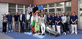 Das Bild zeigt das Team der Kinderklinik gemeinsam mit Geschäftsführer Dietmar Pawlik, Baudirektorin Sonja Pöhlmann, Landrat Florian Wiedemann, Oberbürgermeiter Thomas Ebersberger bei der Eröffnung des Spielplatzes im Innenhof der Kinderklinik vor einem neuen Spielturm.