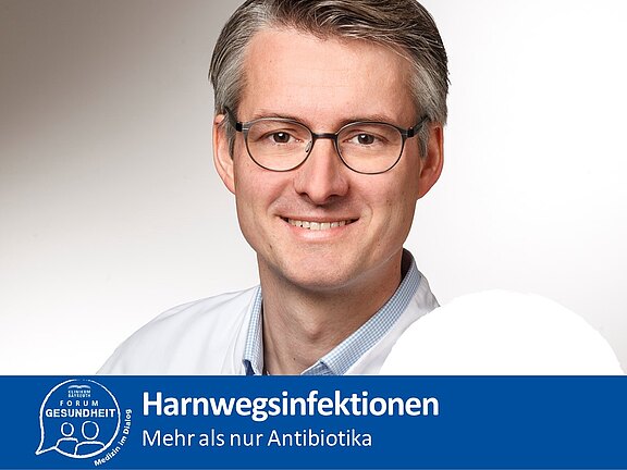 Plakat des Klinikums Bayreuth mit Porträt eines Arztes. Hauptbotschaft: Harnwegsinfektionen – mehr als nur Antibiotika; informiert über alternative Behandlungsansätze.