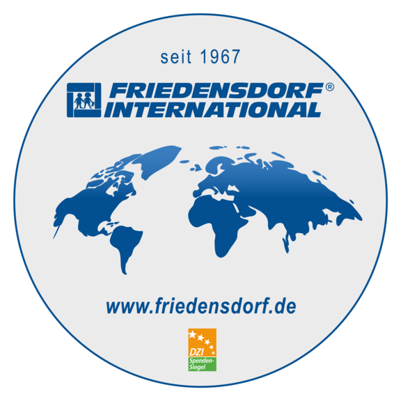Logo von Friedensdorf International: blaue Weltkarte mit Schriftzug „FRIEDENSDORF INTERNATIONAL“, Hinweis „seit 1967“, darunter Webadresse www.friedensdorf.de und das DZI-Spenden-Siegel.