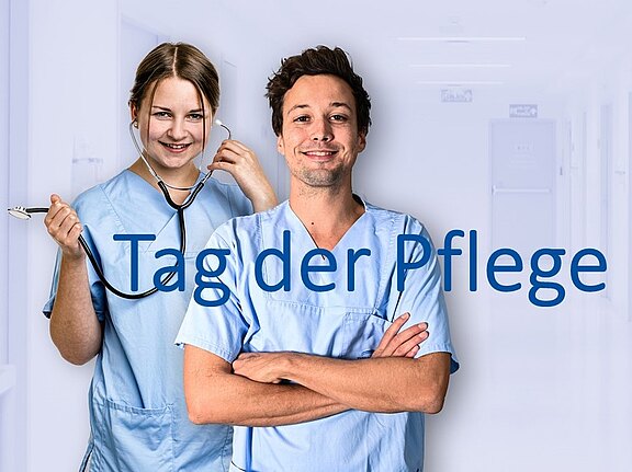 Zwei Pflegekräfte in hellblauer Kleidung lächeln im Krankenhausflur; eine hält ein Stethoskop, der andere verschränkt die Arme. Aufschrift in der Bildmitte: „Tag der Pflege“.