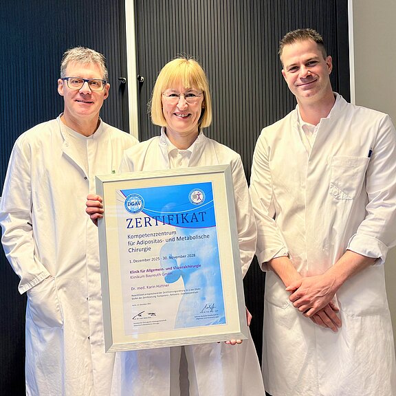 Bild mit Urkunde. Dr. Karin Hüttner, Ärztliche Leiterin des Adipositaszentrums, Dr. Oliver Ponsel, Direktor der Klinik für Allgemein- und Viszeralchirurgie und Oberarzt Dr. (Univ. Niš) Filip Kostic