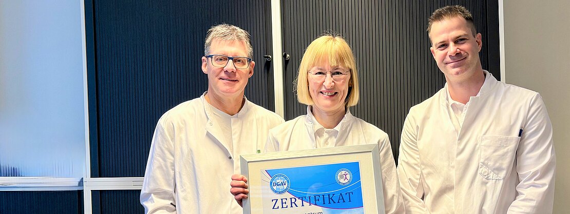 Bild mit Urkunde. Dr. Karin Hüttner, Ärztliche Leiterin des Adipositaszentrums, Dr. Oliver Ponsel, Direktor der  Klinik für Allgemein- und Viszeralchirurgie und Oberarzt Dr. (Univ. Niš) Filip Kostic