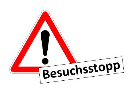 Ein rot-weißes Dreieck mit einem Ausrufezeichen und dem Text "Besuchsstopp" darunter. Das Bild signalisiert eine Warnung oder Anweisung, Besuche zu unterlassen.